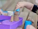 Een kind speelt met wat zand